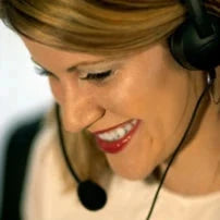 A cheerful person is smiling while wearing a headset, ready to discuss the latest innovations with Tech Support by the Hour from AllSportSystems.