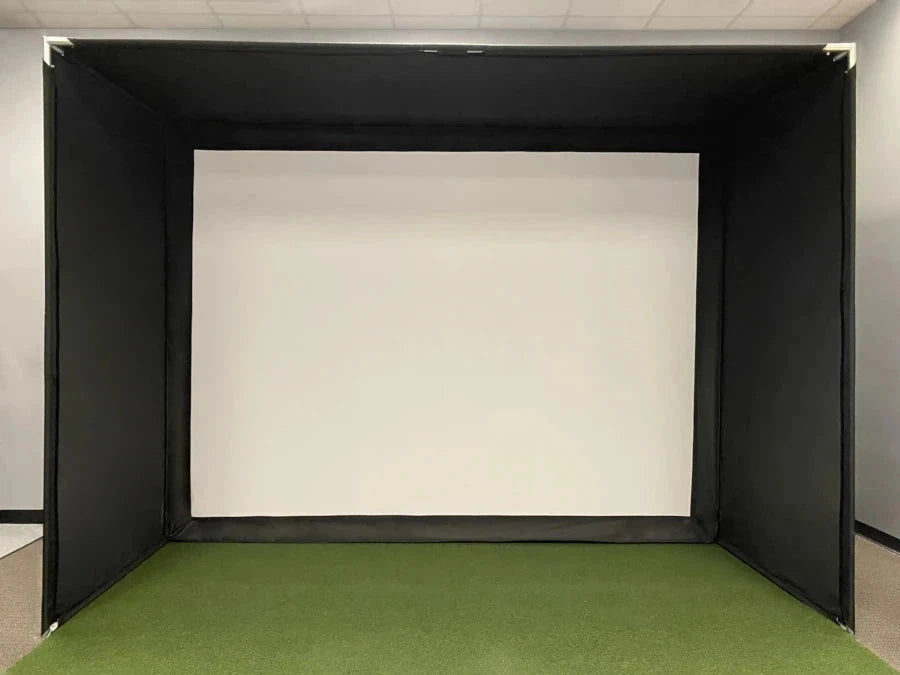 A Super Bay™ LITE™ Golf Simulator Safety Bay by AllSportSystems, featuring a black enclosure with a white screen at the back and green flooring.