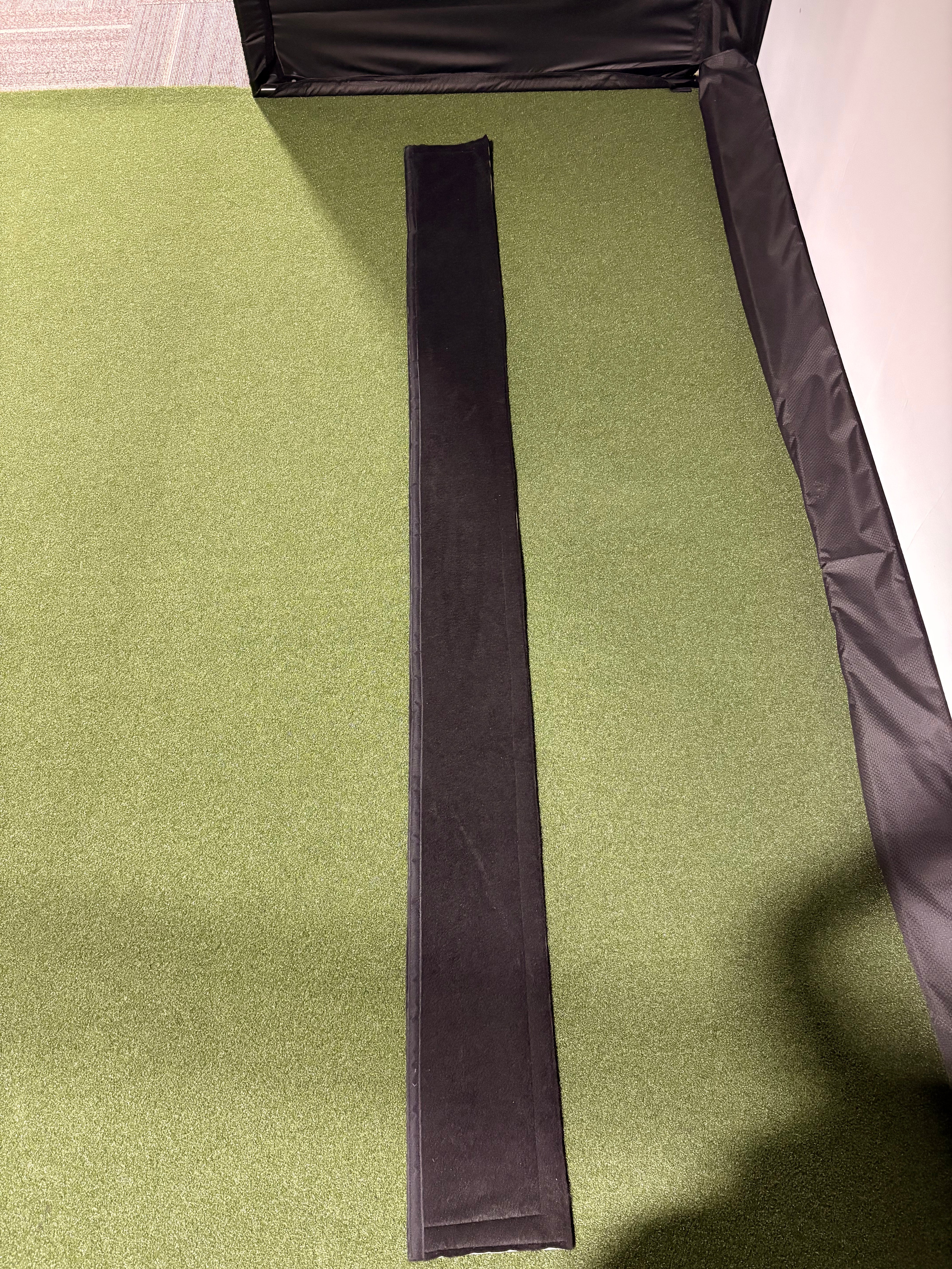 Corner foam padding and trim protect golf simulator pipes from ball hits, stopping ricochets and reducing injury risk.
